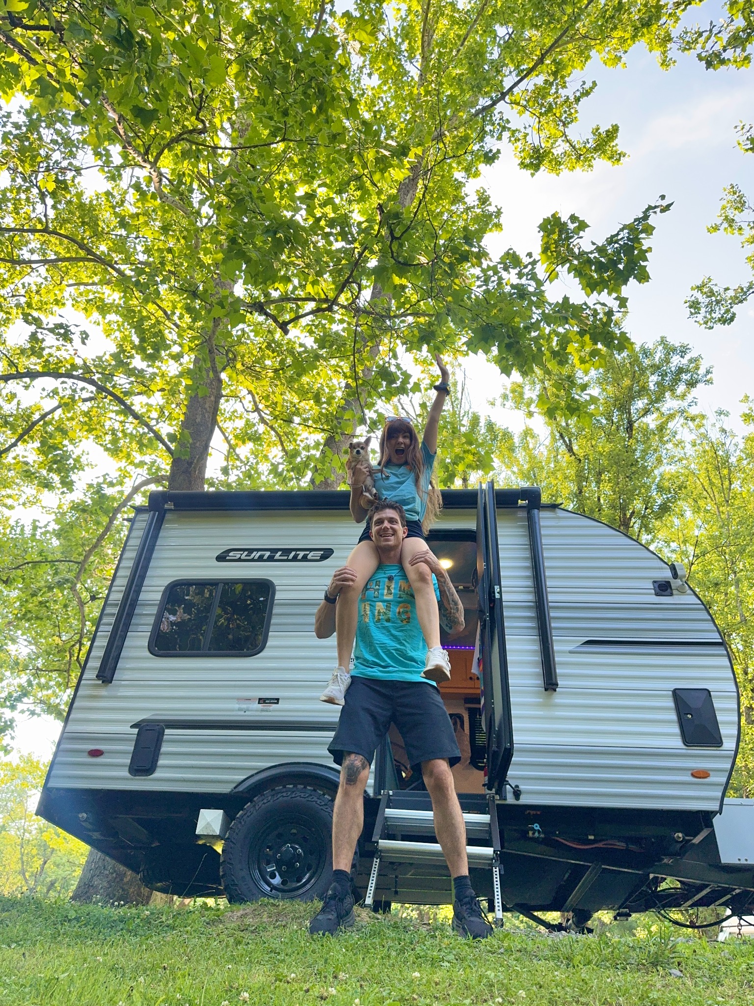 Cassie, Christian, and Sir Meatball in front of their camper
